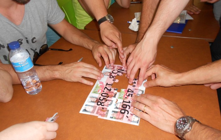 Mãos de várias pessoas sobre um puzzle sobre a mesa.